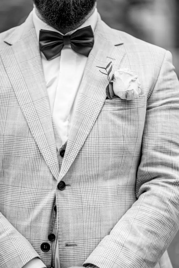 Ansteckblume und Fliege auf dem Hochzeitsanzug