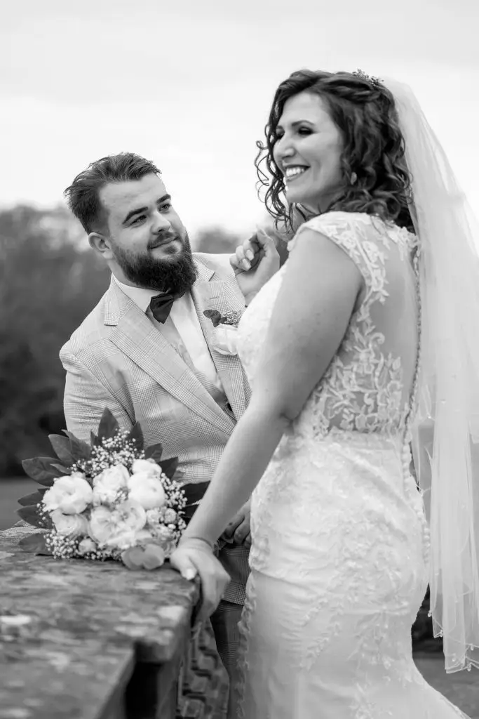 Ein Foto von Braut und Bräutigam, wie sie sich am Schloss Solitude ein Lächeln schenken.