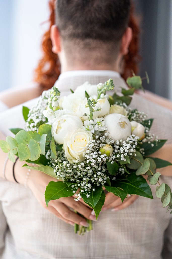 Brautstrauß während der Umarmung mit dem Bräutigam.