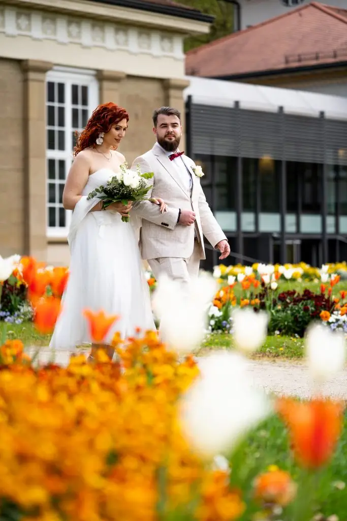 Ein Paar läuft nach der standesamtlichen Trauung zum Auto.